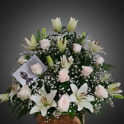 Arreglo fúnebre de rosas blancas y lirios blancos en base de madera con tarjeta de condolencias