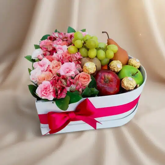 Arreglo AMOS en caja corazón con rosas rosadas, alstroemerias, uvas, manzanas, pera y chocolates Ferrero Rocher, ideal para r