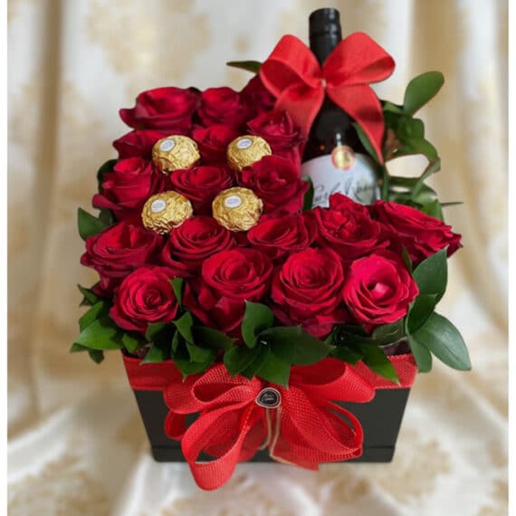 Arreglo floral ENRICO con rosas rojas frescas, botella de vino tinto y chocolates Ferrero Rocher, presentado en una caja negr