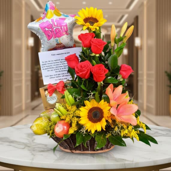 Arreglo Floral con Frutas Kiwano: Regalo Elegante y Fresco Arreglo floral premium con rosas rojas, girasoles, lirios, frutas kiwano y globo 'Feliz Día' sobre mesa de mármol en lobby el
