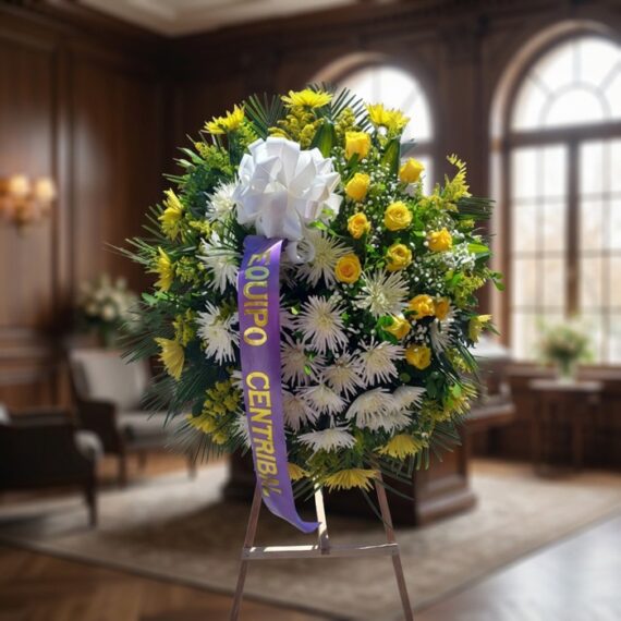 Corona fúnebre 'Estamos Contigo' con flores amarillas y blancas, lazo morado, en sala de velación premium con luz natural sua