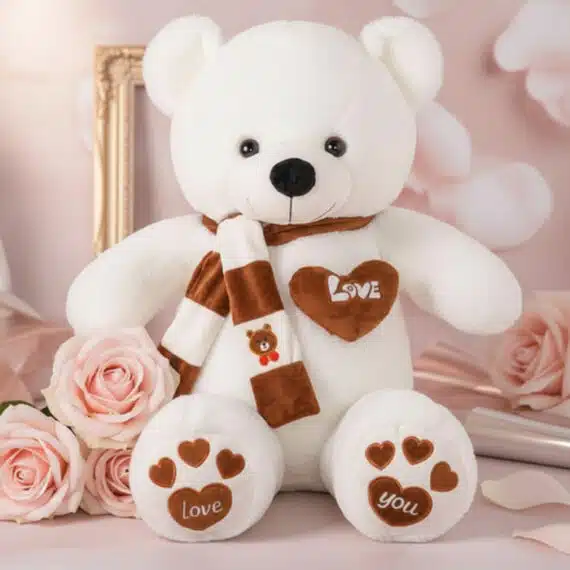 Oso de Felpa Blanco con Rosas Rosadas: El Regalo Perfecto de Amor Oso de felpa blanco con bufanda a rayas marrones y blancas, corazón bordado 'LOVE' y patas con huellas de corazón, rodeado de