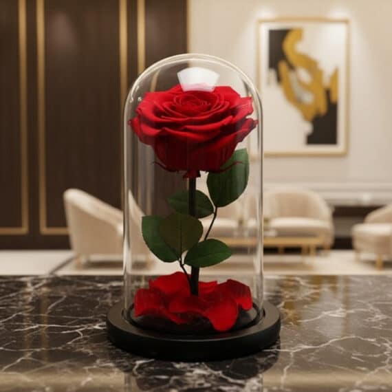 Rosa preservada roja en cúpula de cristal sobre una mesa de mármol negro, con un fondo elegante de lobby de hotel boutique.